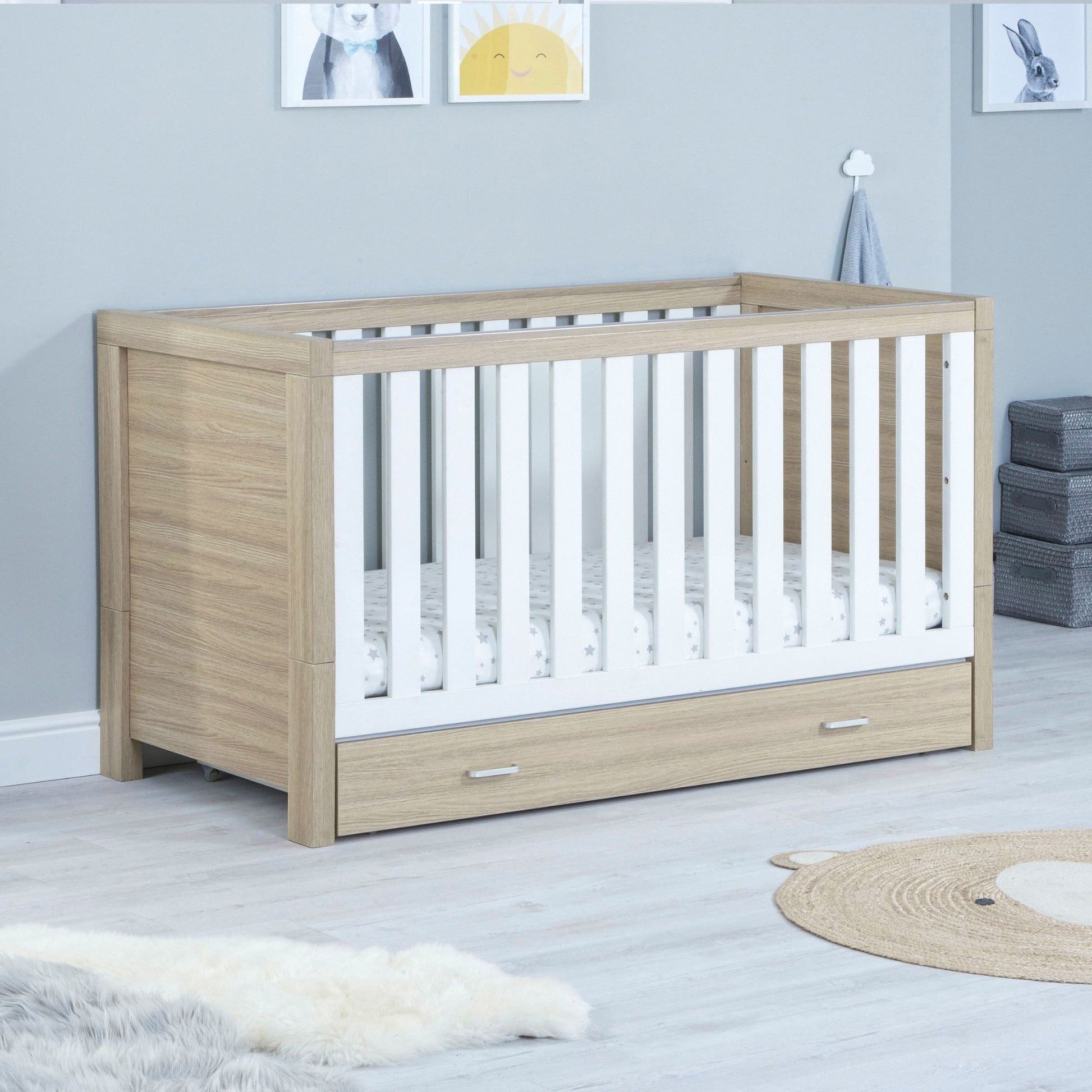 Babymore-Luno-Cot-Bed-oak-white-with-drawer-in-nursery-setting-as cot-side